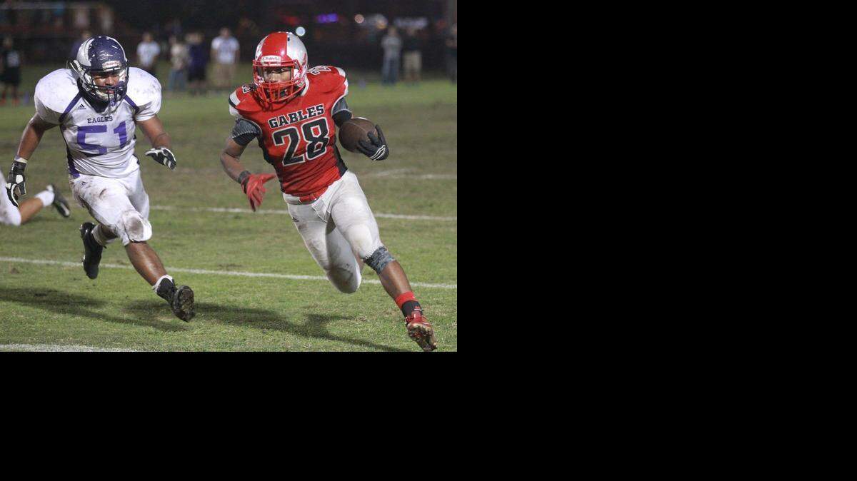 
Mike Keino (28) of Coral Gables High runs for yards in their game against Southwest High at Tropical Park, Friday, Nov. 7, 2014.
