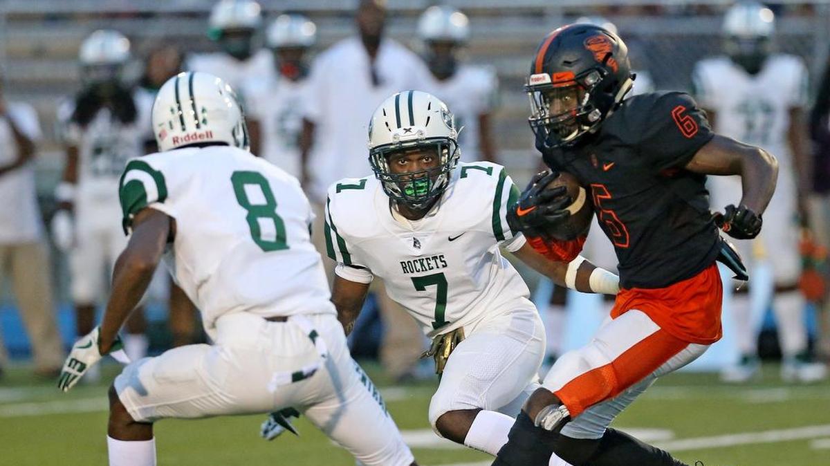 Miami Central’s Andrew Bloodsaw (8) and Shemar Paul (7) close in on Booker T. Washington’s Estamane Lucdor (6) Friday, Aug. 31, 2018, at Traz Powell Stadium in Miami.