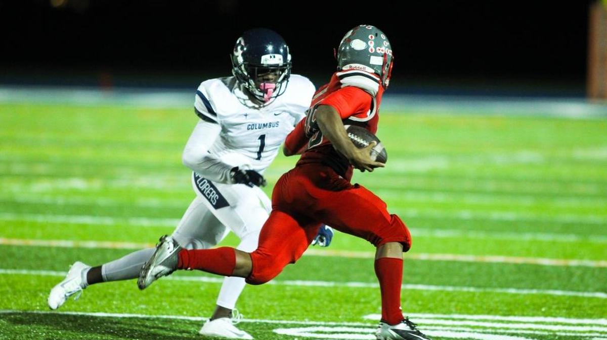 Coral Gables’ Johnny Ford avoids a tackle from Columbus’ Trajan Bandy during a regional semifinal game Friday, Nov. 20, 2015 at Tropical Park in Miami,