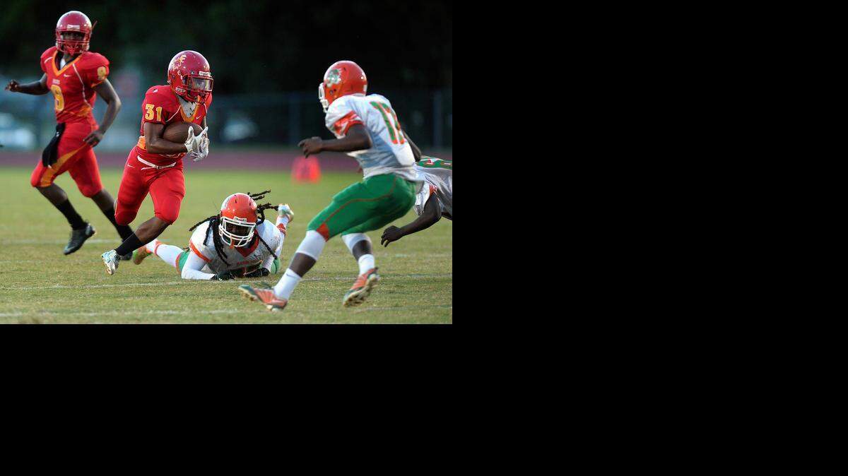 
Deerfield Beach running back Kobe Farrish looks for a hole in the Ely defense during the first half of their game, Friday, Sept. 12, 2014.
