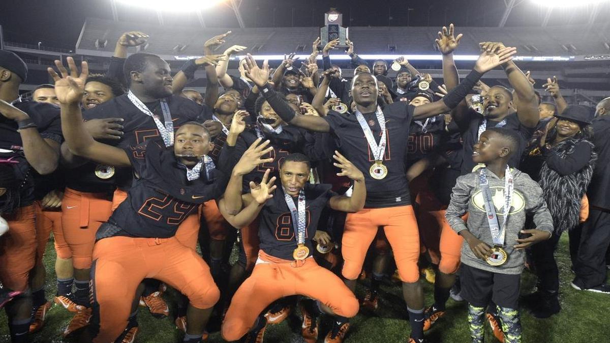 Booker T. Washington players celebrate with the championship trophy after the Class 4A championship game against Raines at the FHSAA State Football Finals in Orlando, Fla., Saturday, Dec. 5, 2015. Booker T. Washington won 43-23.