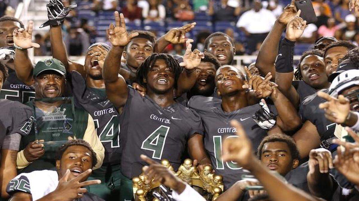 
Miami Central’s Anthony Jones holds the trophy with teammates after defeating Bothell in the Burger King State Championships Bowl Series at FAU Stadium in Boca Raton, Florida, December 27, 2014.
