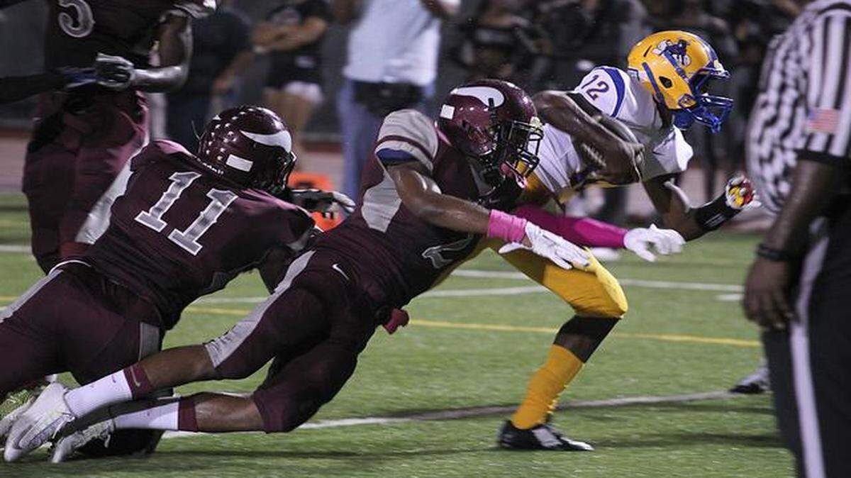 
Northwestern quarterback Chatarius Atwell, right, keeps the ball for yardage and the touchdown in the first half of the football game Northwestern versus Norland at Traz Powell Stadium on Thursday, Oct. 2, 2014.
