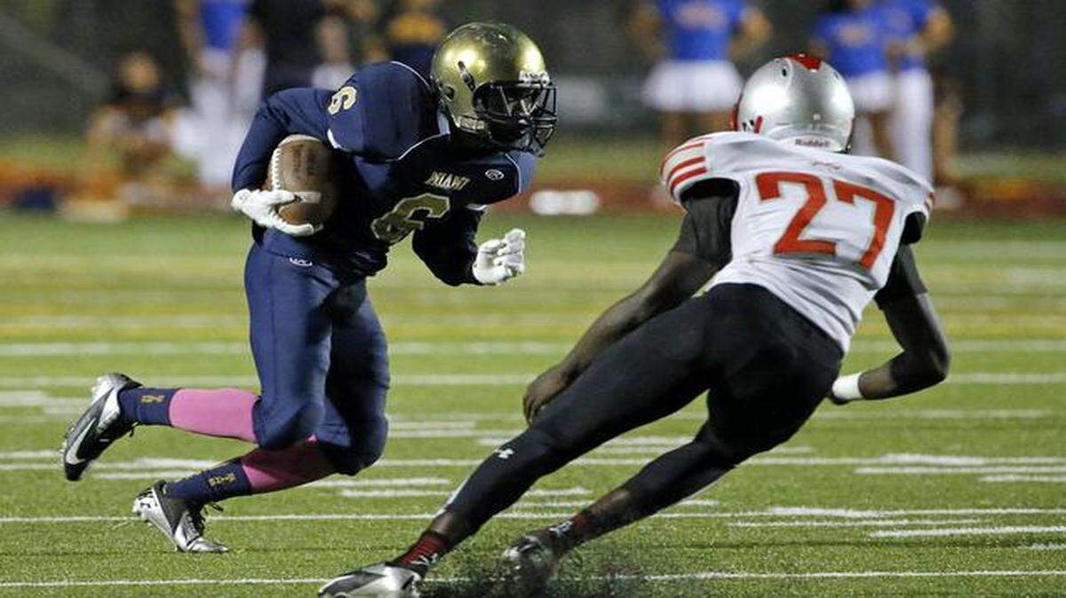 
Miami High's Keith Johnson (6) runs against Coral Gables' Nadarious Fagan (27) in Miami on Friday, Oct. 17, 2014.
