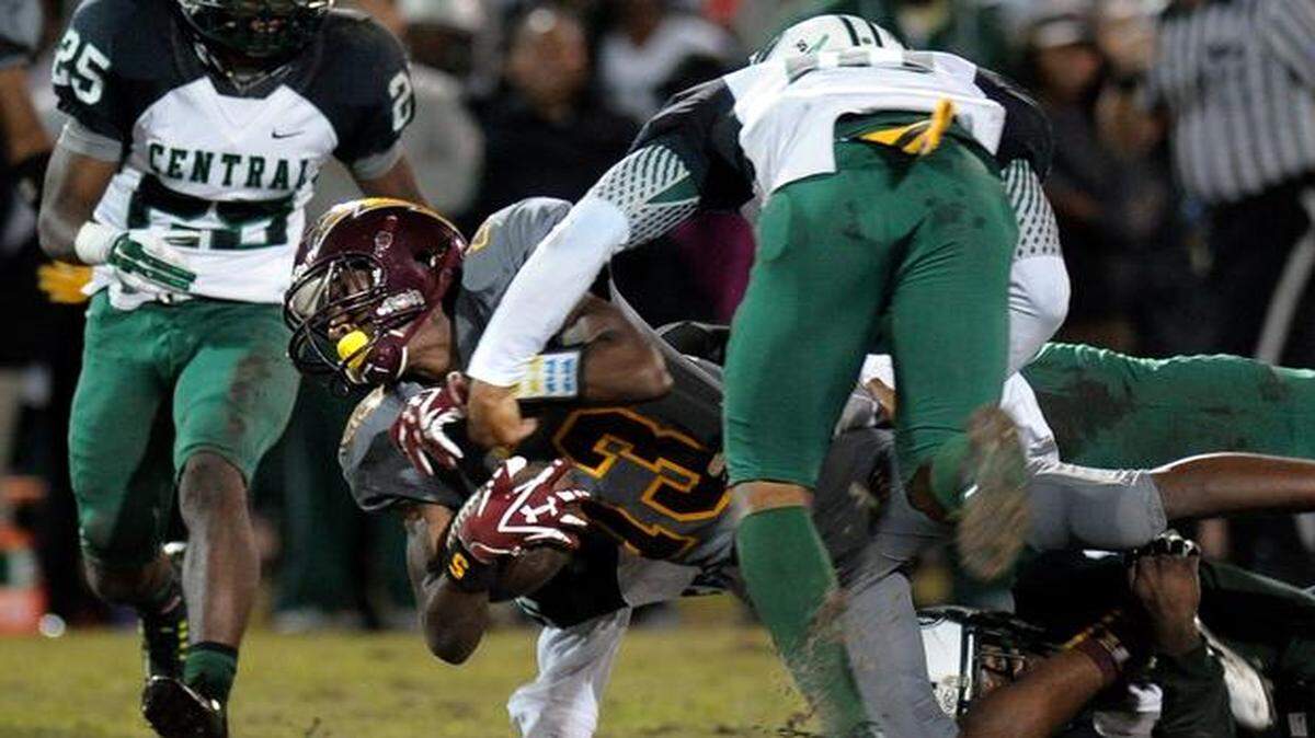
Hallandale receiver Bernard Scott is tackled by several Miami Central defenders during the first half, Friday, Nov. 21, 2014, at Hallandale High School.
