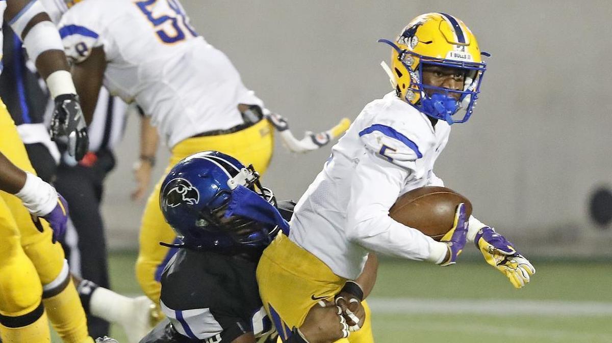 Miami Northwestern Bulls’ Chatarius Atwell Jr. (5) is tackled by the Armwood Hawks’ Allah Whittaker (C) (96) in the first quarter of the Class 6A state high school football championship at Camping World Stadium in Orlando on Friday, Dec. 8, 2017.