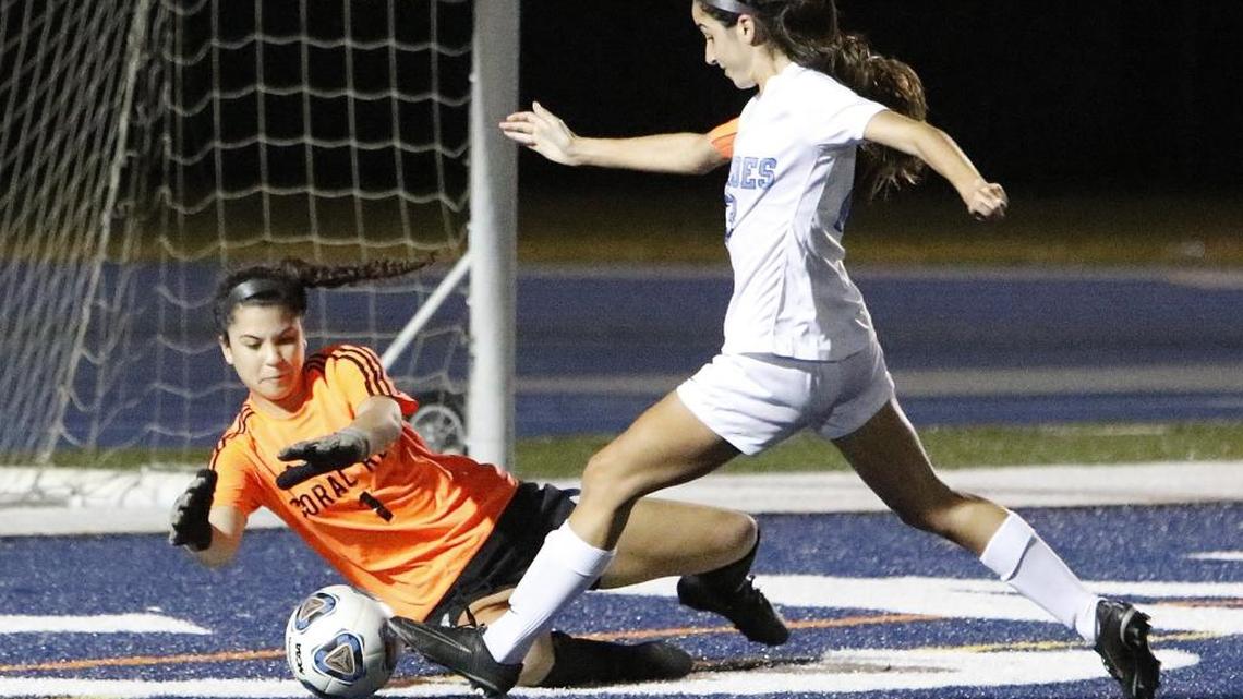 Coral Reef goalkeeper Christina Velasquez makes one of her 16 saves, stopping a shot from Lourdes’ Niki Molina on Friday in a Region 4-5A semifinal match at Tropical Park.