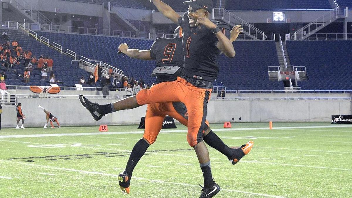 Booker T. Washington's Dedrick Mackey (1) and Craig Nelson (9) celebrate after the Class 4A championship game against Raines at the FHSAA State Football Finals in Orlando, Fla., Saturday, Dec. 5, 2015. Booker T. Washington won 43-23.