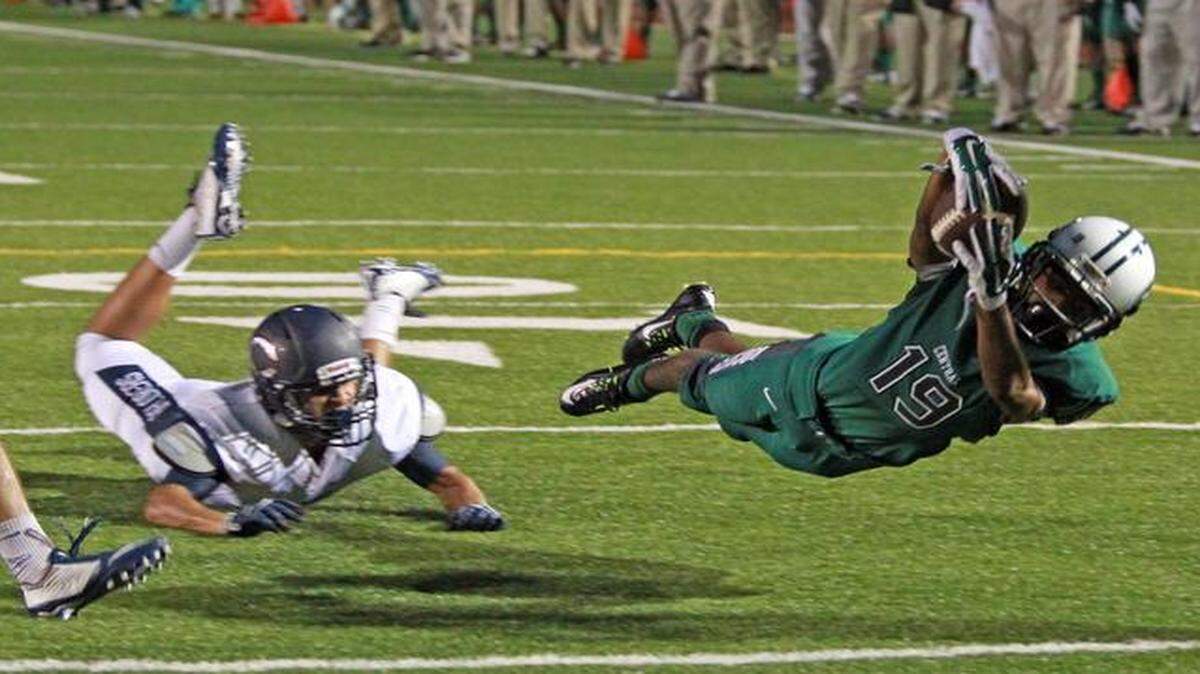 
Miami Central's Lenwood Joyner dives for a second-quarter touchdown as Christopher Columbus High's Andrew Rosenfeld can't stop him at Traz Powell Stadium, Sept. 18, 2014.
