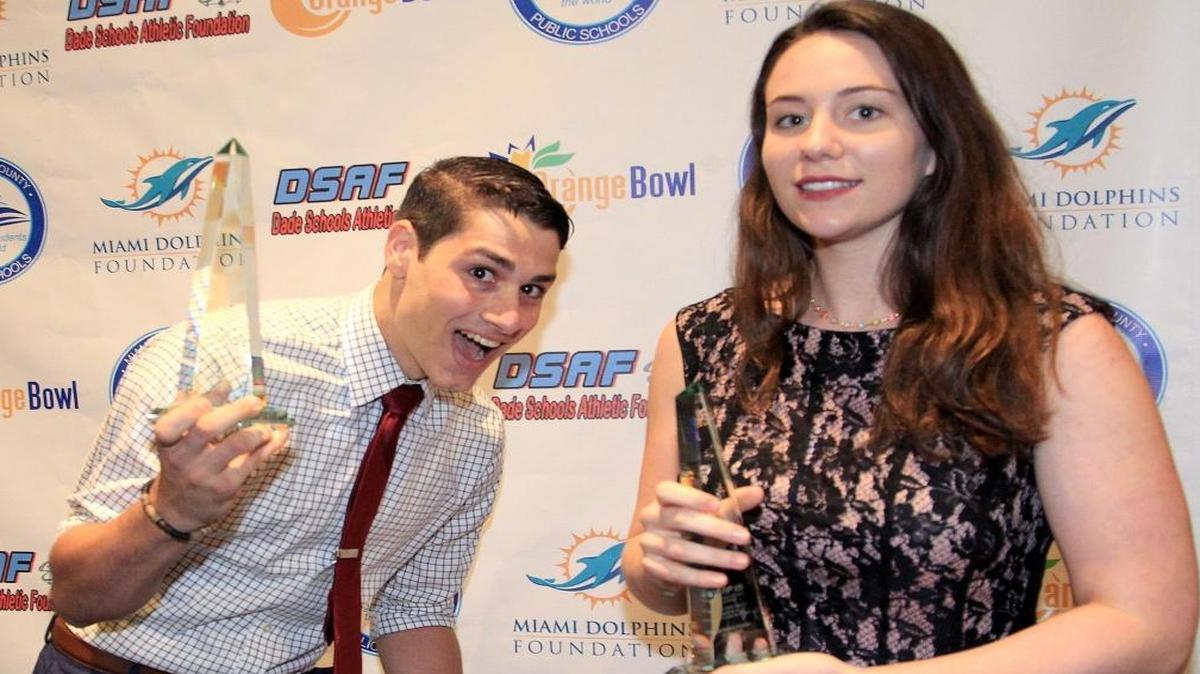 Randall Elkind, of Varela High, left, and Catarina Vale, of TERRA High, right, are this year's recipients of the William R. Nash/Dade Schools Athletic Foundation Scholarships. The pair take their trophies back to their seats on Mon., April 25, 2016.