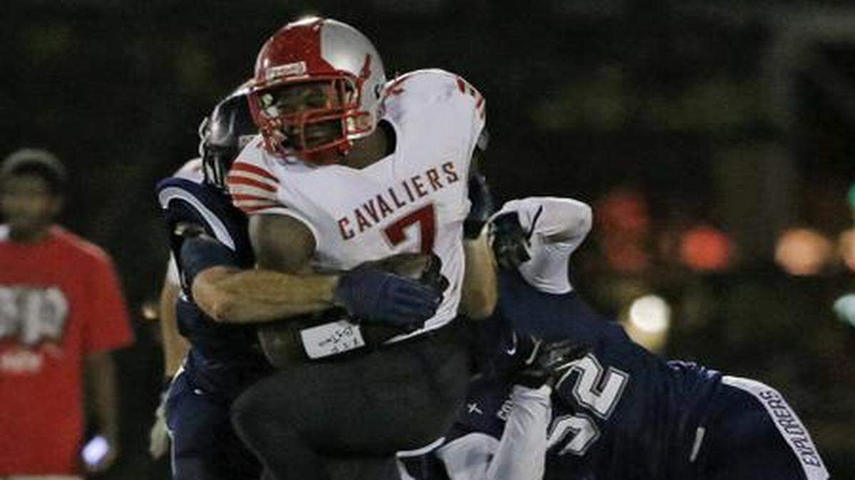 
Coral Gables' Shaquery Wilson (7) is tackled by Columbus' Bryce Handy (52) at Tropical Park in Miami on Nov. 20, 2014.
