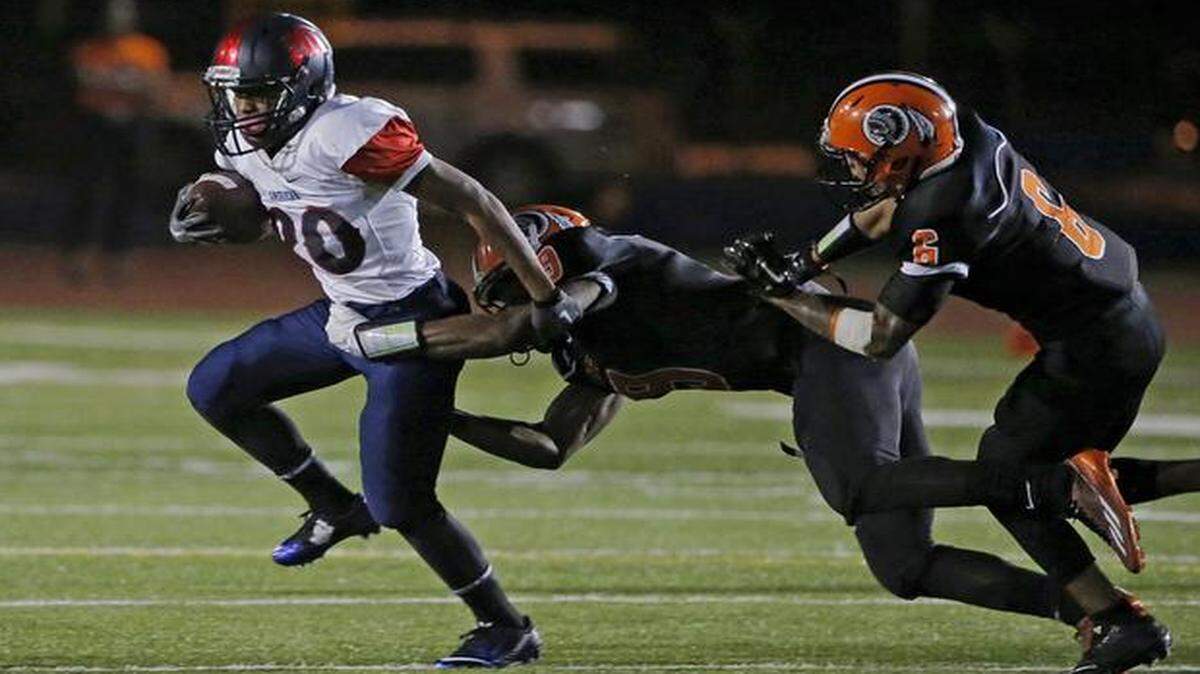 
American’s Lytii Borders (20) is pursued by Carol City’s Edward Rolle (9) on Thursday, Nov. 6, 2014.
