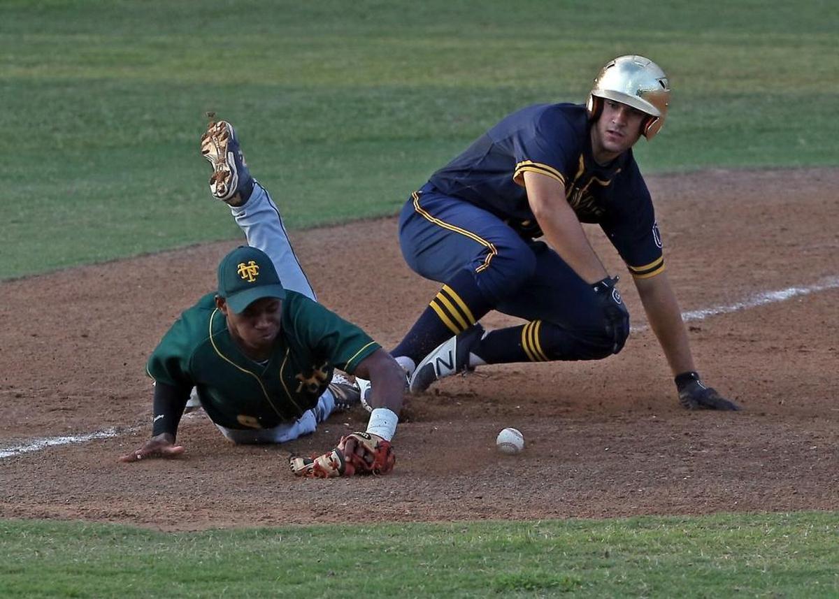 St. Thomas Aquinas' #18 Kyle Benson slides past the tag of Nova third baseman #9 Jordan Campbell after hitting a long fly ball to center field in the second inning as St. Thomas Aquinas visits Nova in regional baseball final on Tues., May 23, 2017.