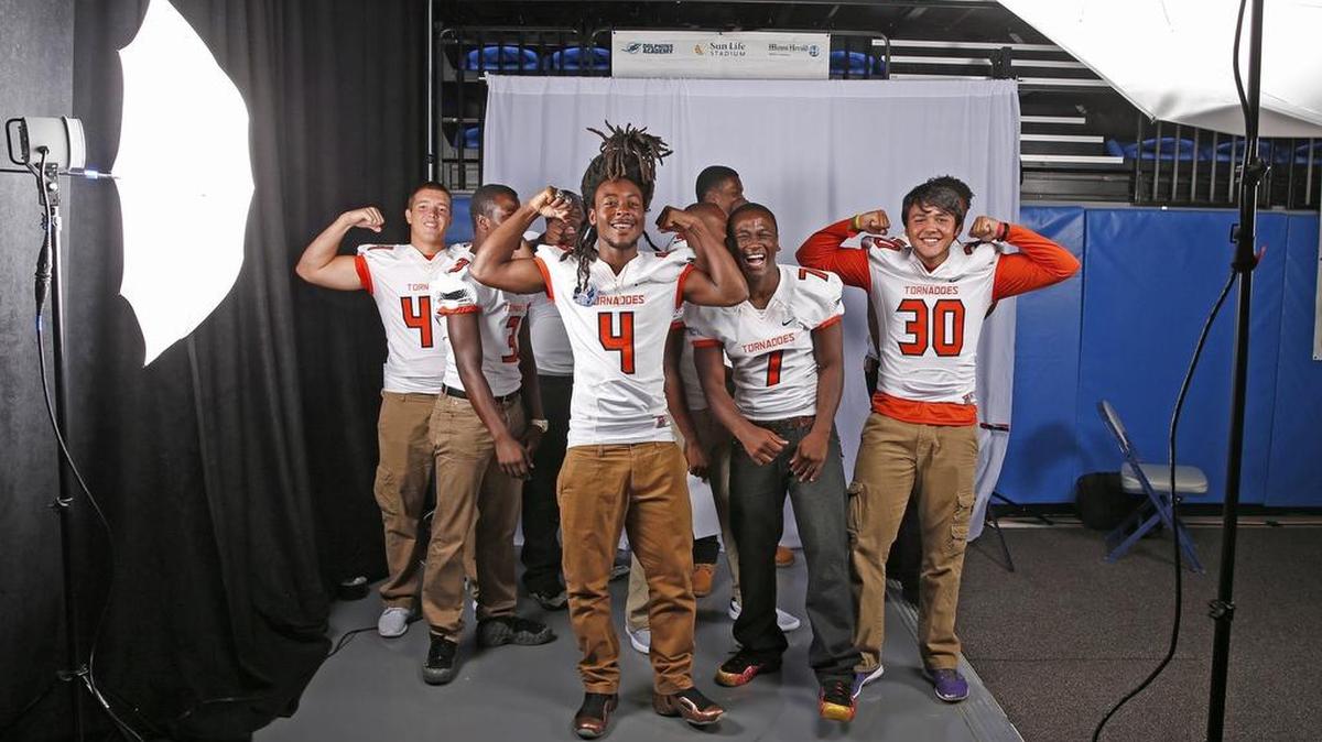 
Booker T. Washington players (front, left to right) Darrius Scott, Marlon Pelote and Jose Borregales enjoy their moment in the spotlight with teammates at the Dolphins’ high school football media day in August.
