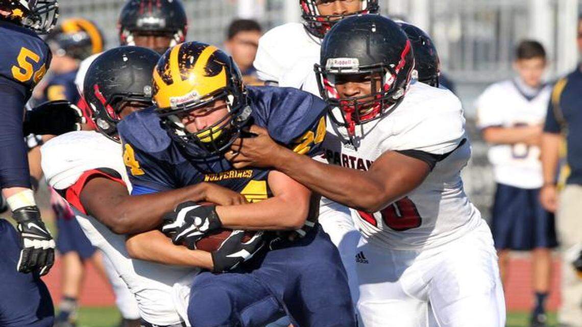
Belen Jesuit's Mario Robaina fights hard for some yards as Miami Southridge's Clarence Moss (32) and Nathaniel Cushnie (60) try to bring him down in the regional playoffs at Belen Jesuit high school on Friday, Nov. 14, 2014.
