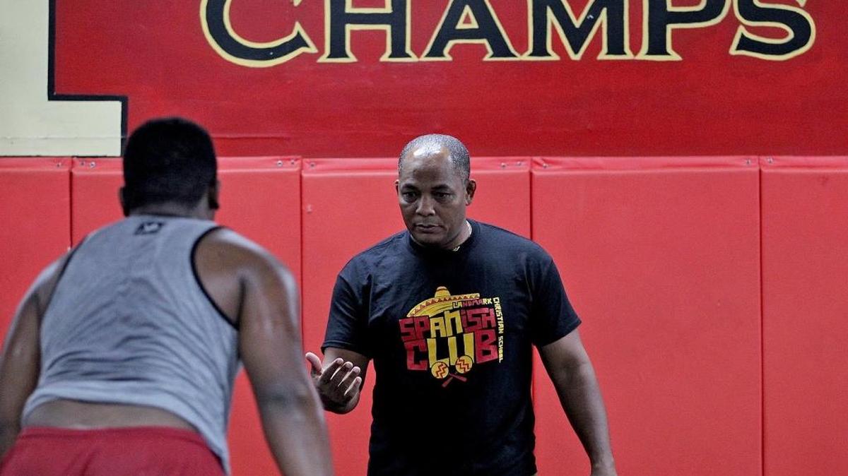 Lazaro Reinoso, who won an Olympic bronze medal in 1992 and is now an assistant wrestling coach at Monsignor Edward Pace High School, coaches his athletes on Monday, Dec. 11, 2015.