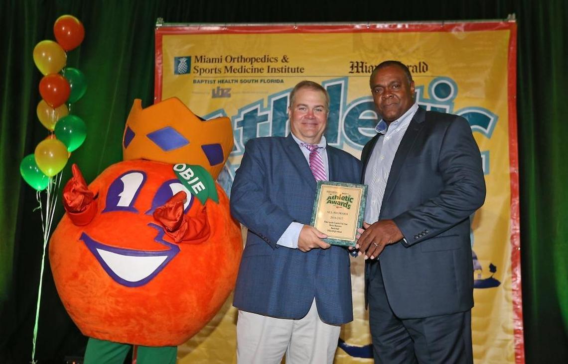 Herald Sportswriter George Richards presents the Male Sports Coach of the Year award to Dillard's Darryl Burrows at the Miami Herald Broward Athletic Awards banquet at the Signature Grand in Davie on Thurs., May 25, 2017.