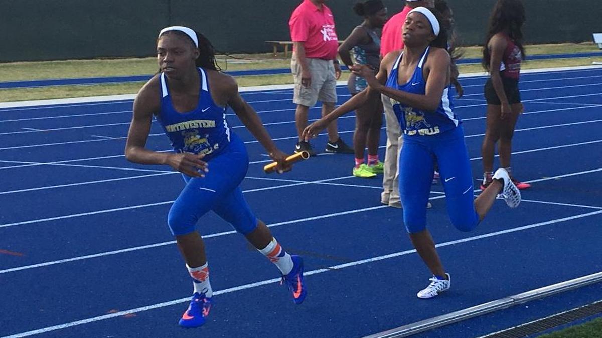 Northwestern’s Timetria Mitchell, left, takes the baton from teammate De’Andreah Young during the 1,600-meter relay at the GMAC track and field championships Tuesday, March 15, 2016, at Tropical Park in Miami.