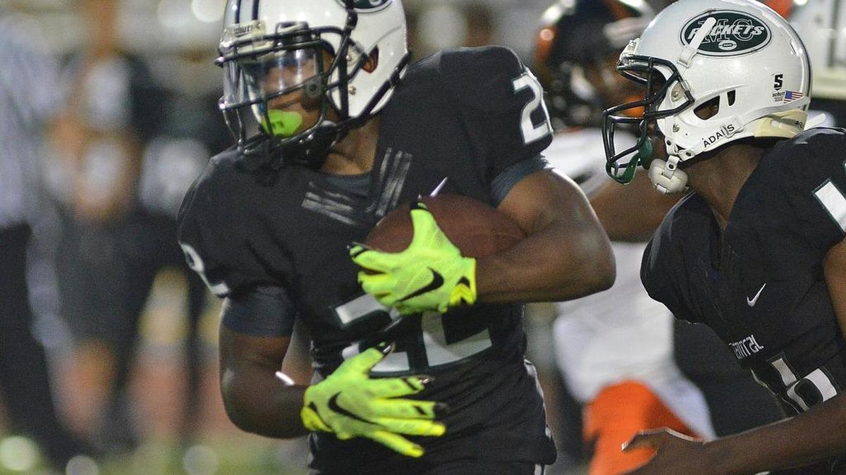 
Miami Central running back Robert Khori takes the ball for yards in the first half of a high school football game Saturday night Sept. 26, 2015 against Booker T. Washington high school.
