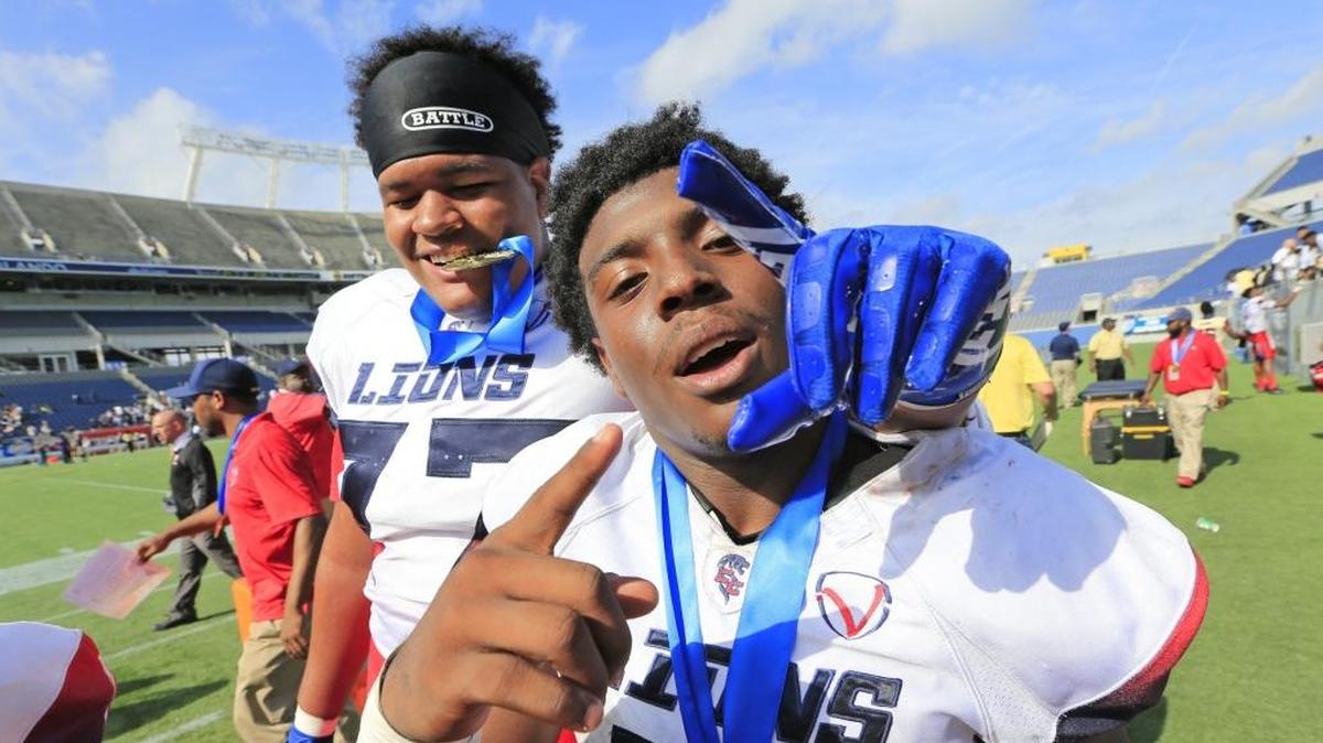 Champagnat Lions Terrence Crittenden (7) and Khiry Stubbs (77) celebrate after defeating University Christian 24-7 in the Class 2A State High School Football Championship at Camping World Stadium in Orlando on Friday, Dec. 8, 2017.