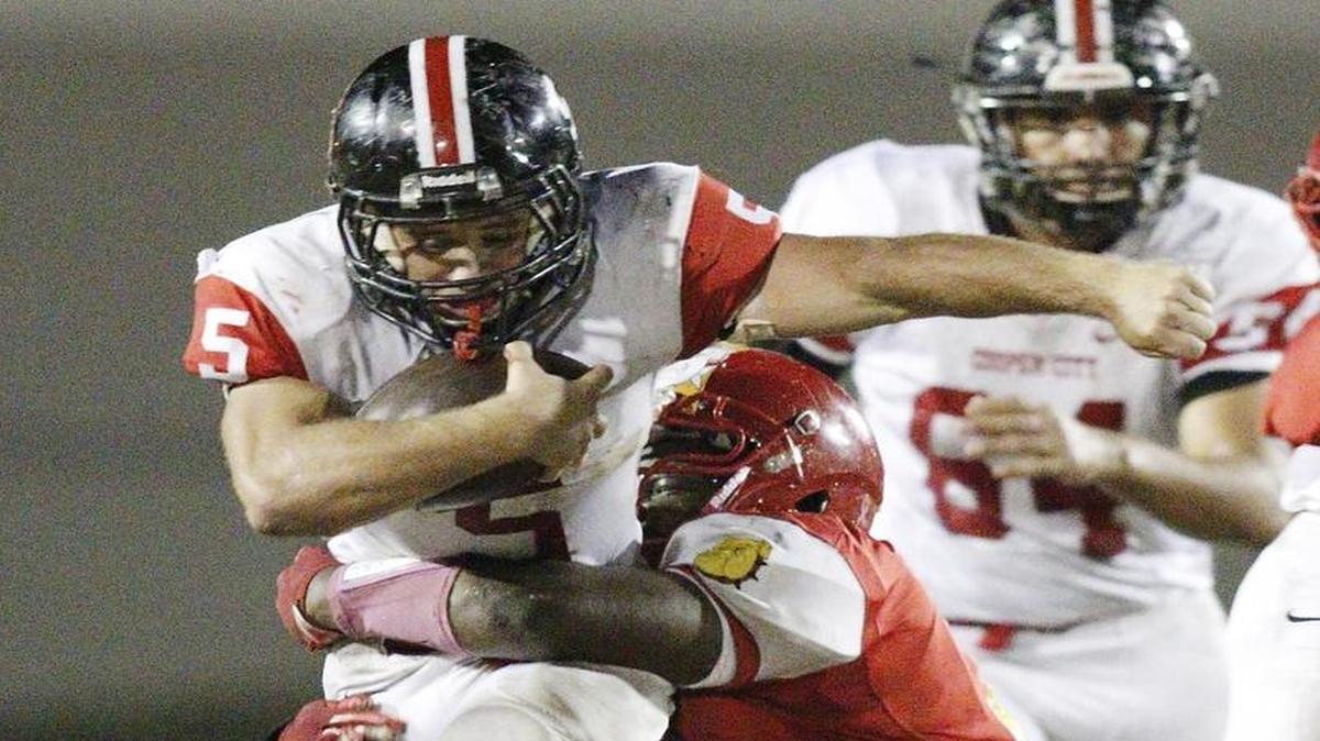 Cooper City running back Tyler Brown (5) attempts to escape a tackle by South Broward Bulldogs defender during their game on Friday, October 21, 2016 at South Broward HS in Hollywood.