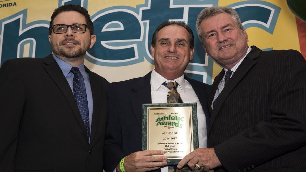 Miami Herald sportswriters Andre Fernandez and Bill Daley present Belen Jesuit football coach Rich Stuart with the Lifetime Achievement Award at the Miami Herald Miami-Dade Student Athletic Awards Ceremony on Tues., May 23, 2017.