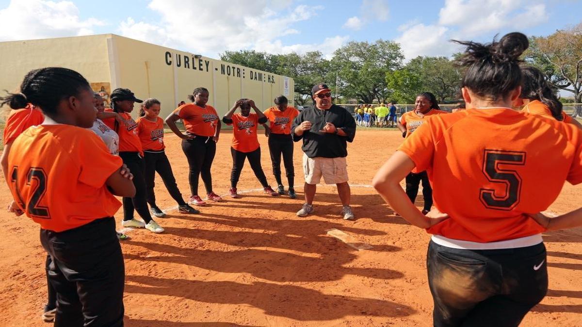 Archbishop Curley/Notre Dame High School head softball coach Greg Cabana gives his players a post-game pep talk following their last home game ever at Curley. Curley hosted Marathon for the final high school athletic event in the school's history on April 11, 2017.