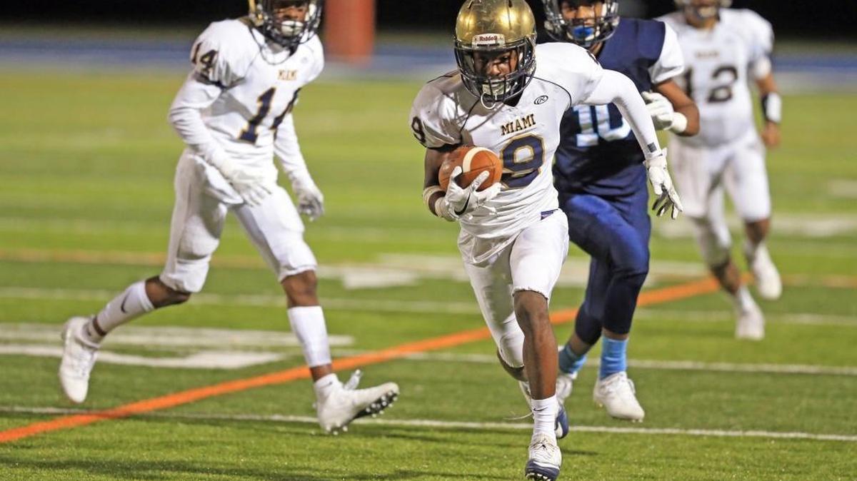 Miami High's wide receiver Bernard Marshall (9) scores on a pass reception in the first quarter as Palmetto High plays Miami High in football playoff game at Tropical Park Stadium on Thurs., Nov. 9, 2017.
