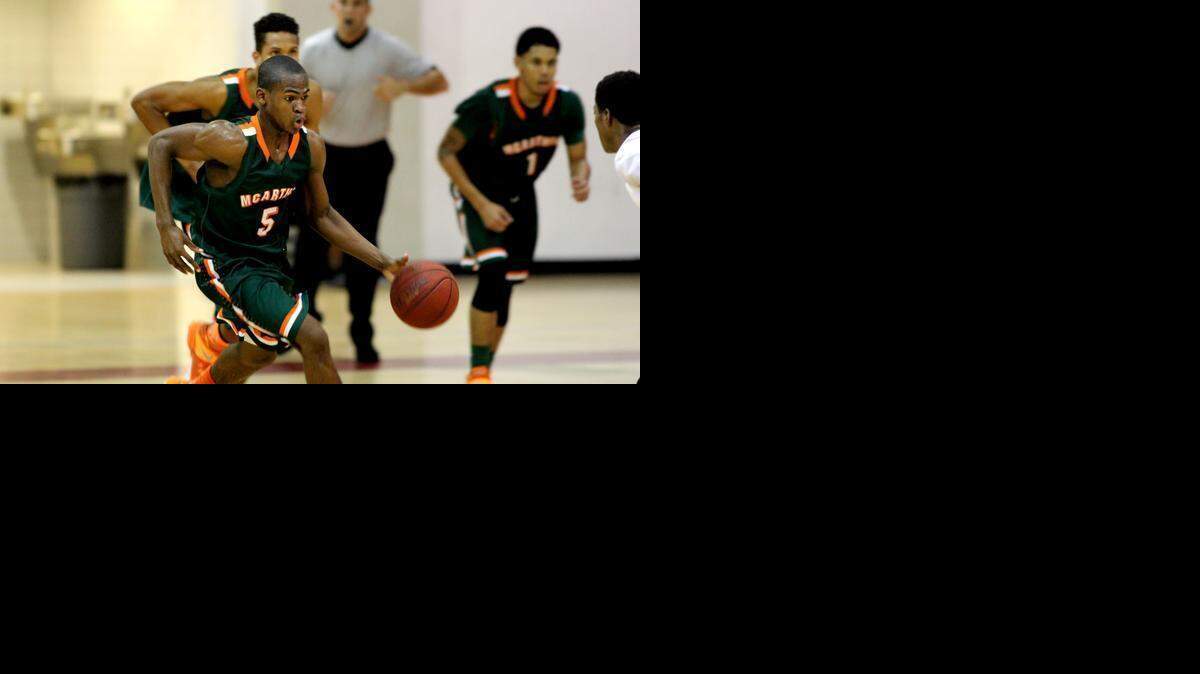 
McArthur High School’s Derric Jean dribbles down the court against Miami Beach on Feb. 17, 2015. 
