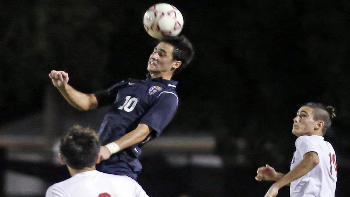 Belen Jesuit’s Francisco De La Camara heads the ball away from South Broward’s Lautaro Saleme (6) during a boys’ region semifinal match Tuesday, Feb. 2, 2016 at South Broward.