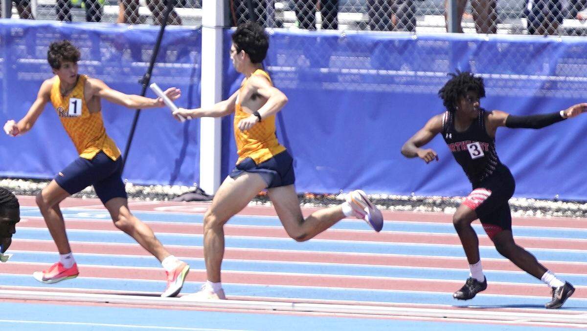 Belen Jesuit’s Marcelo Mantecon receives the baton from teammate Armando Cruz during the 4x800 relay at the Region 4-3A Track & Field Championships in Miramar.