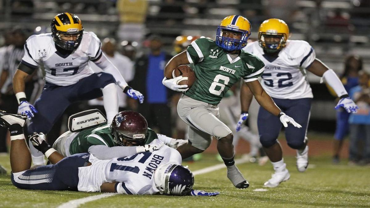 The North's Corey Lane , (8), of Northwestern breaks tackles during the Miami-Dade All-Star football game (north vs. South) at Curtis Park on Saturday, December 19, 2015.