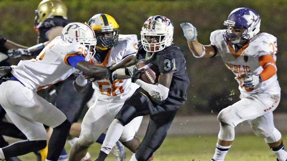 
Private school's Marquise Brown of Chaminade-Madonna Prep runs for yardage as he is pursued by public school defenders in the fourth quarter at Monsignor Pace on Saturday, January 10, 2015.
