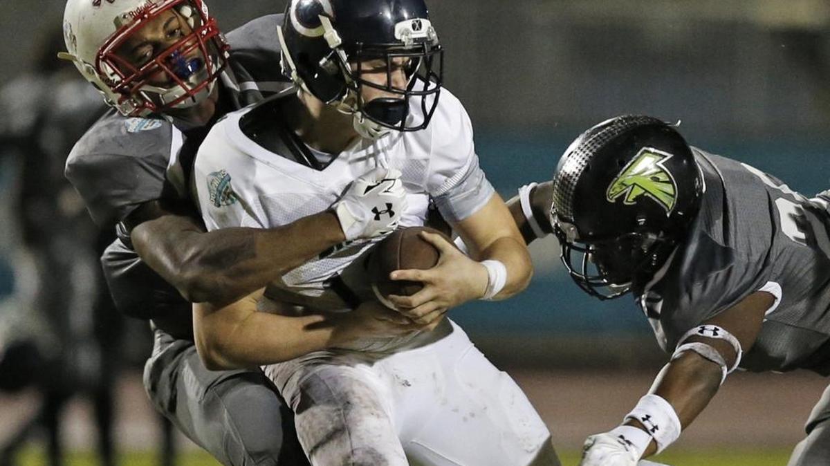 Miami Dade quarterback Alex Ros of Columbus High is sacked by Broward’s Tyrik Jones of Plantation, left, and Fabian Gordon of Flanagan, right, during the Dade-Broward All-Star High School football game at Flanagan High School in Pembroke Pines, FL on Friday, January 15, 2016.