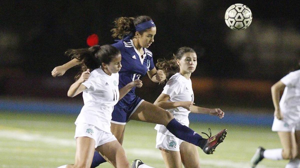 Palmetto’s Valentina Fernandez, center, slices through two Coral Reef defenders in the GMAC title game.