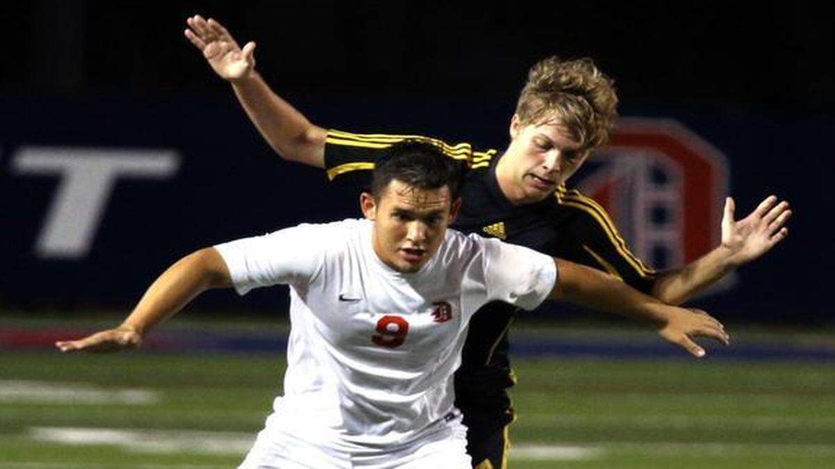 
Doral Academy’s Christain Cervantes blocks American Heritage’s Devon Northard as they play in the Region 4-3A boys’ soccer semifinal at Doral Academy, Feb. 3, 2014.
