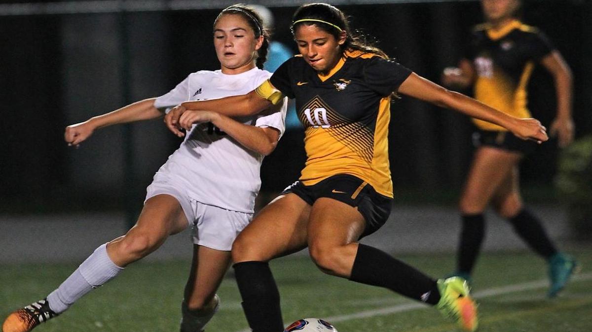 Miami Springs' Jasmine Romay (13) tries to defend American Heritage's Emily Vazquez (10) during a girls' soccer playoff at Milander Park on Tues., Jan. 31, 2017.