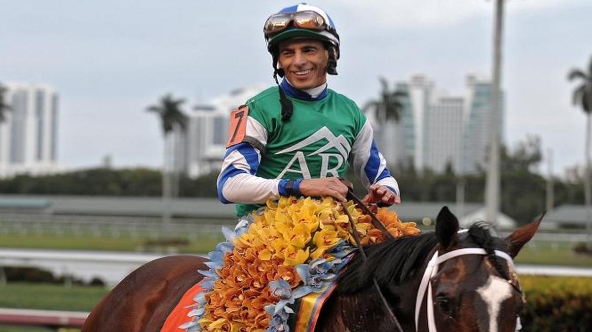 John Velazquez poses for photos with Materiality, the winning horse from the 2015 Florida Derby, at Gulfstream Park, Saturday, March 28, 2015.