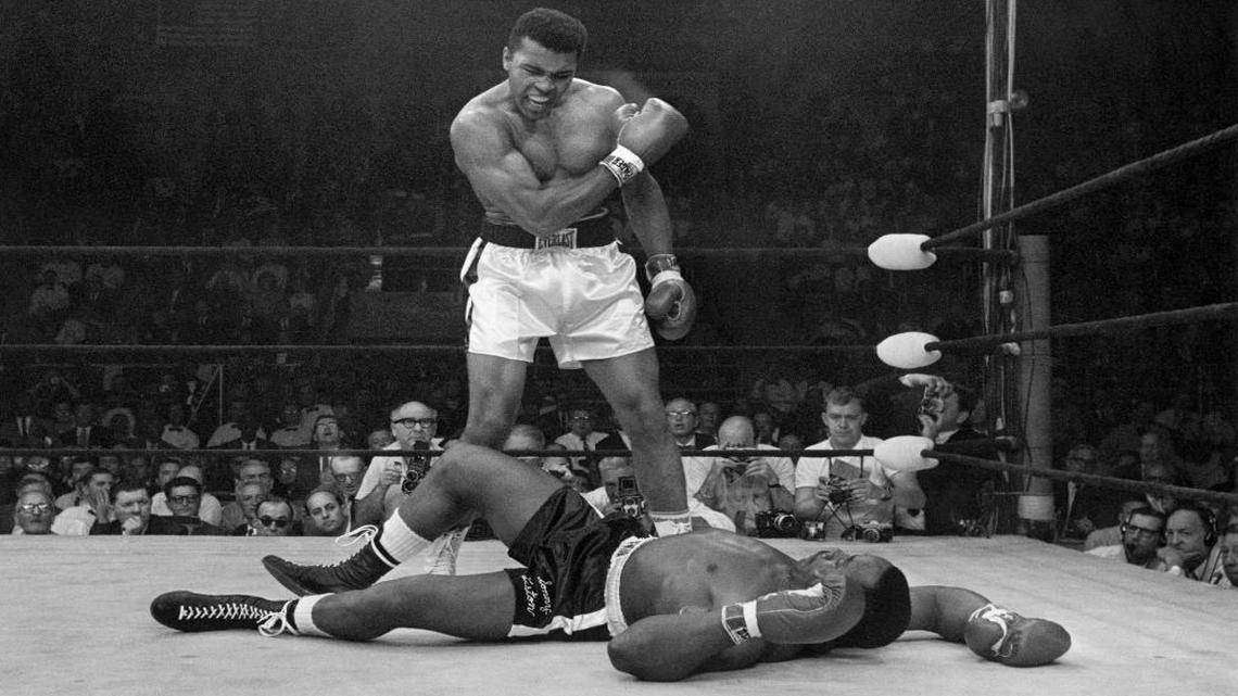 Heavyweight champion Muhammad Ali stands over fallen challenger Sonny Liston, shouting and gesturing shortly after dropping Liston with a short hard right to the jaw, in Lewiston, Maine. On that last ride, the one through his hometown, the windshield of the hearse was covered with so many strewn flowers the driver could barely see the road let alone the throngs lining the streets.