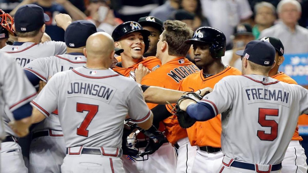 Miami Marlins starting pitcher Jose Fernandez, center, is surrounded by Atlanta Braves players at home plate after an altercation broke out when Fernandez crossed home plate after hitting a solo home run in the sixth inning during a baseball game, Wednesday, Sept. 11, 2013, in Miami.