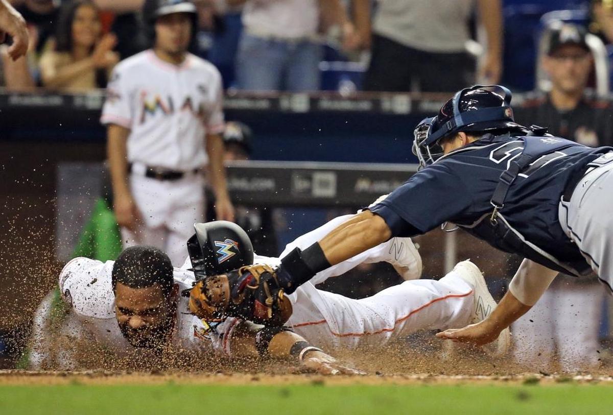 Miami Marlins first baseman Tomas Telis (18) is tagged at home by Atlanta Braves catcher Kurt Suzuki (24) in the seventh inning as the Marlins host the Atlanta Braves at Marlins Park on Fri., Sept. 29, 2017.