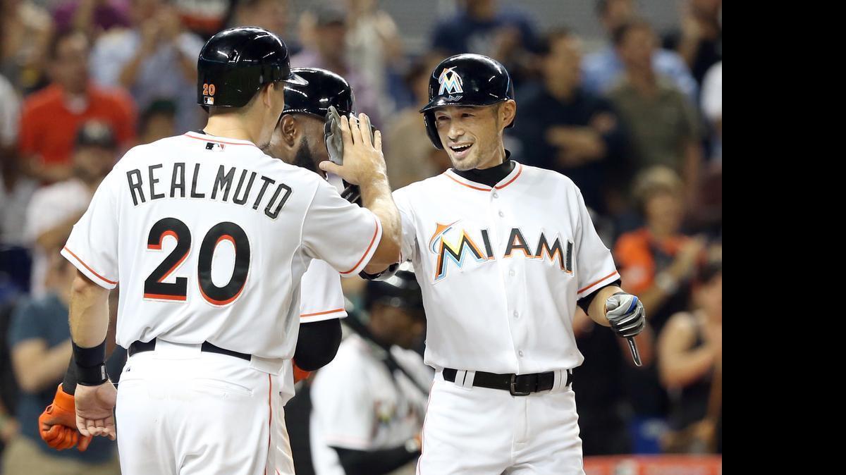 
J.T. Realmuto and Marcell Ozuna greet Miami Marlins teammate Ichiro Suzuki, right, after Suzuki’s three-run home run in the eighth inning against the New York Mets at Marlins Park in Miami on Wednesday, April 29, 2015.
