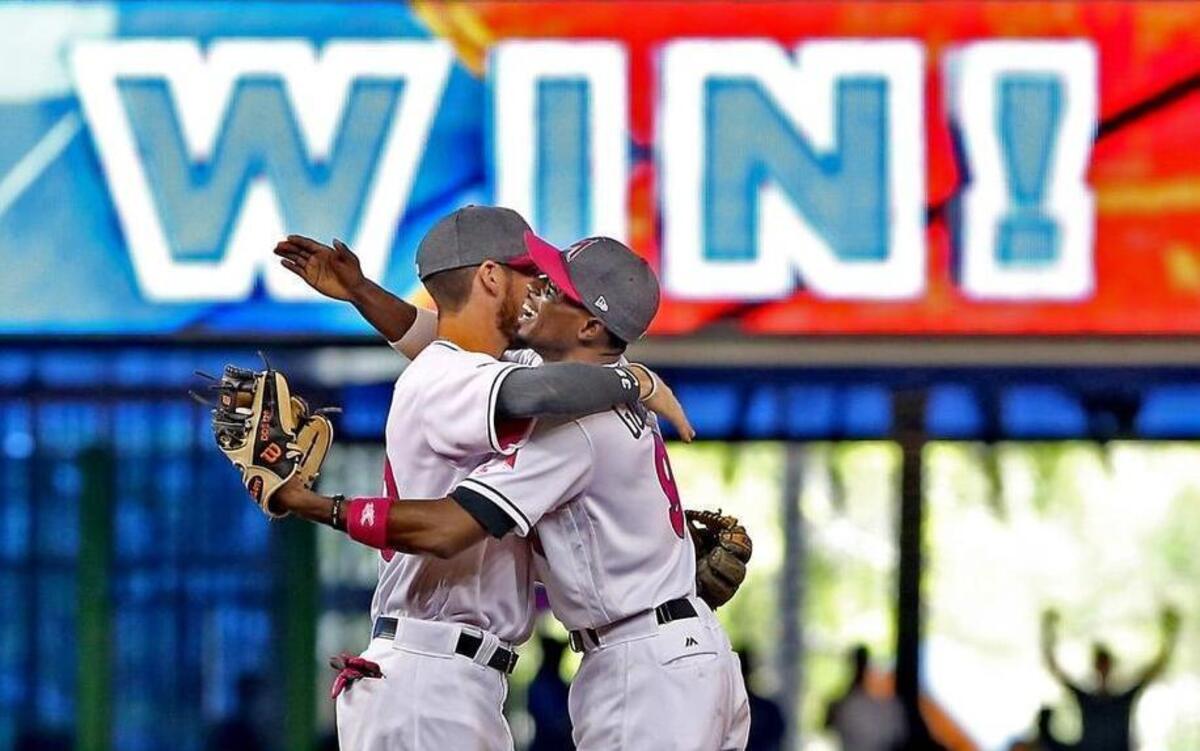 The Marlins' J.T. Riddle (390 and Dee Gordon (9) embrace after the Miami Marlins beat the Atlanta Braves on Sunday, May 14, 2017.