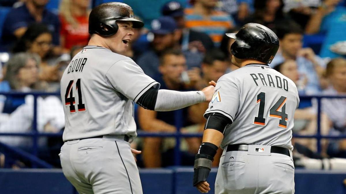 Miami Marlins' Justin Bour and Martin Prado celebrate after they scored on a single by Marcell Ozuna during the third inning of a baseball game against the Tampa Bay Rays on Wednesday, May 25, 2016, in St. Petersburg, Fla.