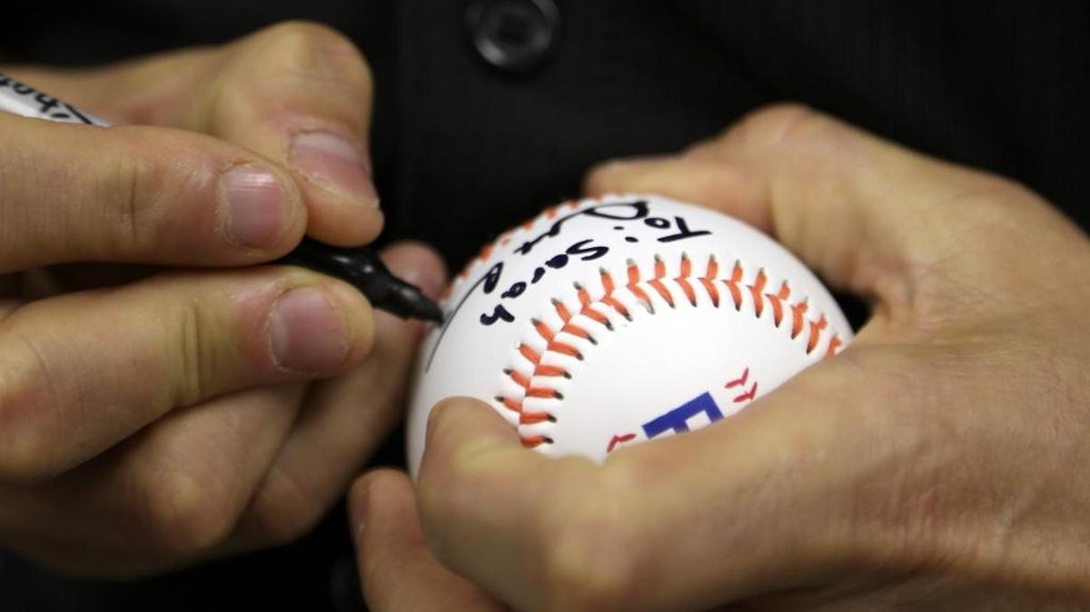 Miami Marlins pitcher Dustin McGowan signs baseball for children suffering from diabetes.