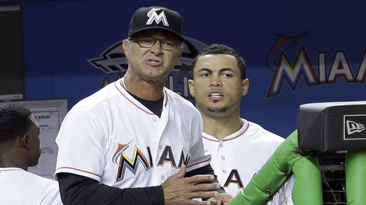 Miami Marlins manager Don Mattingly, left, questions a call by home plate umpire Kerwin Danely as Giancarlo Stanton, right, listens during the fourth inning of a baseball game against the Atlanta Braves, Fri., April 15, 2016, in Miami.