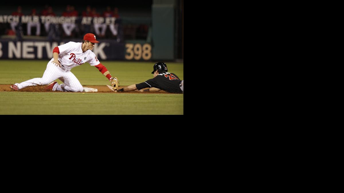 
Philadelphia Phillies second baseman Chase Utley, left, reaches to tag out Miami Marlins' Christian Yelich, right, during the third inning of a baseball game on Sept. 13, 2014, in Philadelphia. Yelich was ruled safe but overturned by replay.
