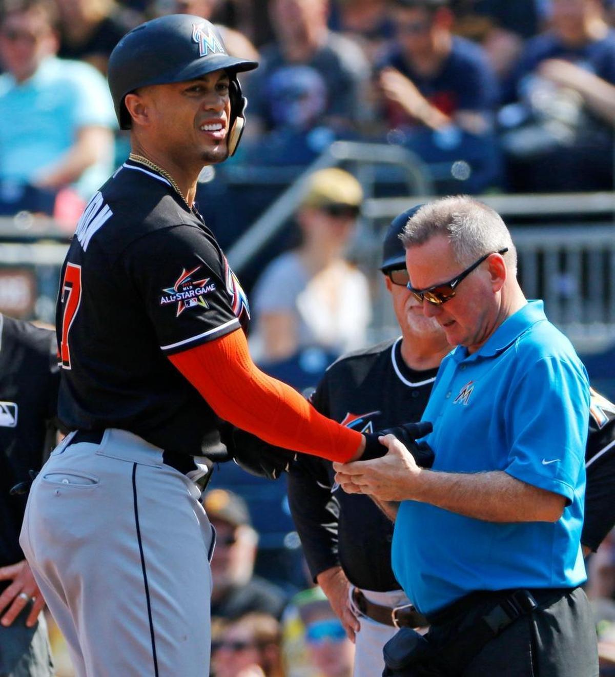 A team trainer, right, examines the hand of Miami Marlins' Giancarlo Stanton, left, after Stanton was hit by a pitch from Pittsburgh Pirates starter Trevor Williams in the first inning of a baseball game in Pittsburgh, Saturday, June 10, 2017. Stanton left the game after the examination.