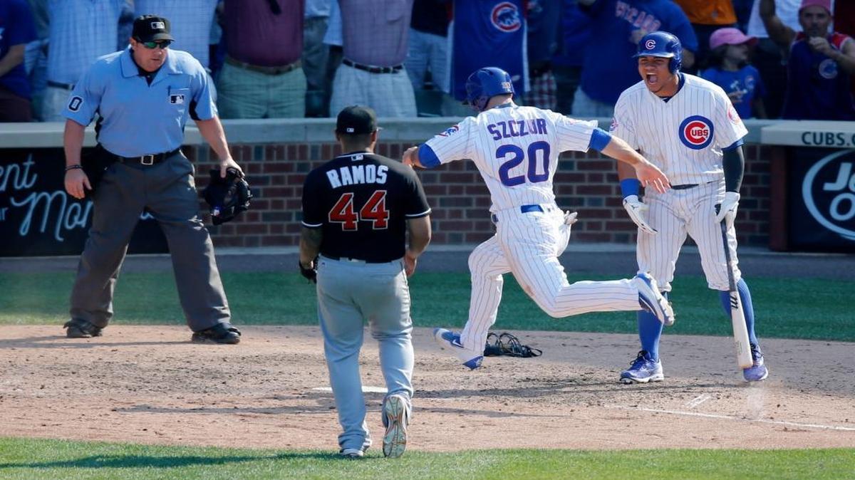 Chicago Cubs' Matt Szczur (20) scores the winning run on a wild pitch from Miami Marlins relief pitcher A.J. Ramos (44) as Willson Contreras and umpire Marty Foster watch during the ninth inning of a baseball game Wed., Aug. 3, 2016, in Chicago. The Cubs won 5-4.