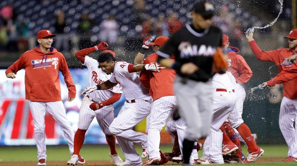 Philadelphia Phillies' Jimmy Paredes (41) and teammates celebrate after Paredes' game-winning RBI-single during the 13th inning of a baseball game against the Miami Marlins, Fri., Sept. 16, 2016, in Philadelphia. Philadelphia won 4-3.
